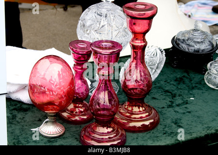 Drei rötlich Glas Stick Kerzenhalter mit auf rötliche Glasbaumbehang Tabelle auf einem Tisch Stockfoto
