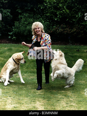 Gloria Hunniford TV-Moderatorin im Garten mit Hunden Stockfoto