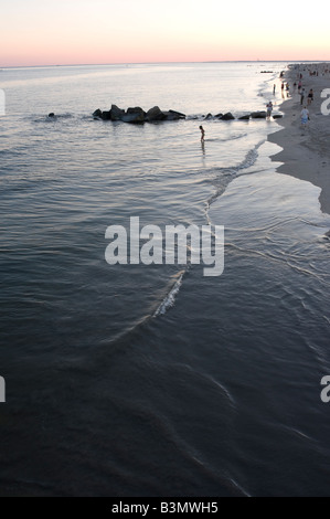 Menschen am Strand von Coney Island in der Abenddämmerung. Labor Day Wochenende inoffiziell zum Ende des Sommers Stockfoto