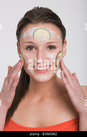 Junge Frau eine Gurke Gesichtsmaske anwenden Stockfoto