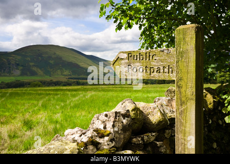 Holz- öffentlichen Fußweg Wegweiser unterzeichnen und Trockenmauer mit Blick auf Lake District in Cumbria, England, Großbritannien Stockfoto