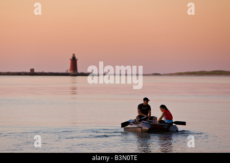 Ein junges Paar Paddel über die Delaware-Bucht in Richtung Mole Leuchtturm am Cape Henlopen State Park. Stockfoto