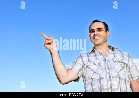 Glückliche Mann mittleren Alters gestikulieren auf blauen Himmelshintergrund Stockfoto
