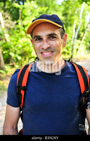 Porträt der glückliche Mann mittleren Alters auf einem Waldweg Stockfoto