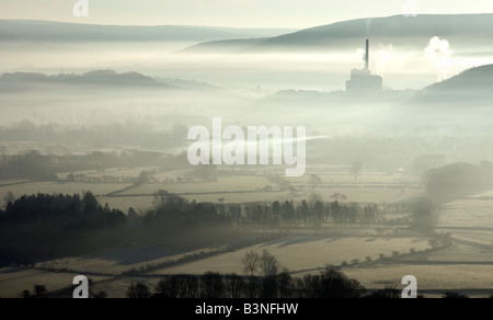 Neblige Sicht über das Tal in Richtung Castleton mit dem Zement arbeitet Schornstein in der Ferne Stockfoto