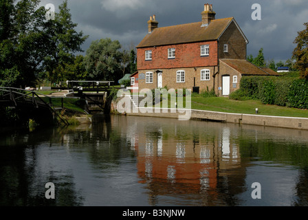 Die Schleusenwärter Hütte bei Stoke Lock spiegelt sich im Fluss Wey Navigation, vor den Toren Guildford, Surrey, England Stockfoto