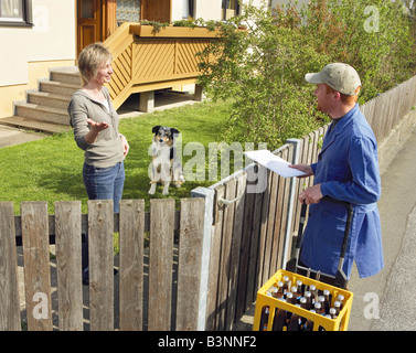 Frau mit australian Sheperd und Getränke Zusteller / Stockfoto