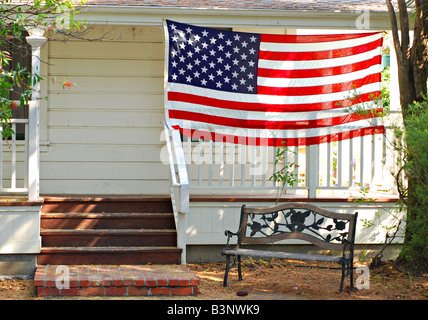 Amerikanische Flagge hängen auf der Veranda eines alten Bauernhauses Stockfoto