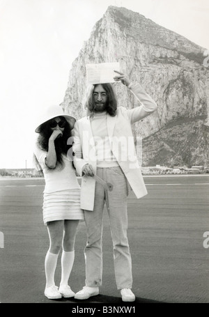 John Lennon hält seine Heiratsurkunde über seinem Kopf, wie er mit seiner Frau Yoko Ono kurz nach ihrer Hochzeit in Gibraltar März 1969 steht Stockfoto
