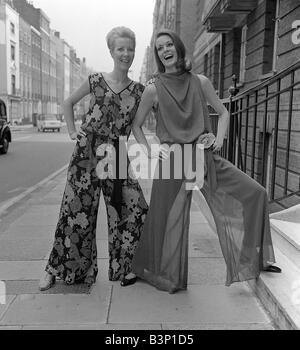 Swinging Sixties Collection Fashion Mode-Shooting in London Modelle Norma Swift L und Alexis Drury zwei Frauen tragen Fackeln in der Straße posiert mit ihren Händen auf ihren Hüften Stockfoto