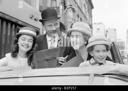 Hüte von Milliner Victor Hyett gesehen hier modelliert in London Straße vor 1959 Kinderbekleidung faire Modelle tragen Stroh Hut Melone sitzen im Auto Kleidung Mode Hüte Familie Mutter Vater Töchter Geschäftsmann Regenschirm Aktentasche November 1959 1950er Jahre Mirrorpix Cyril Maitland 2 11 1959 L7984 Stockfoto