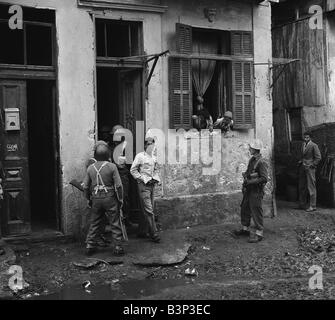 Suez Krise 1956 Truppen von D Company 1. Bataillon Argyll und Sutherland Highlanders führen Sie eine Suche von Häusern in der arabischen Stadt Bezirk Port Said nach einem Armee-Jeep eine Handgranate beworfen wurde die Suche 13 ergab Gewehre, von denen einige waren russischer Herkunft, die sechs Araber verhaftet wurden, die Menschen stehen auf der Straße Stockfoto
