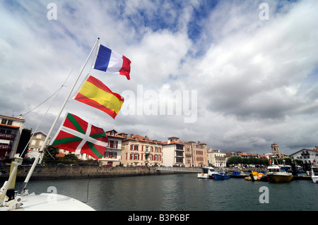 Drei Fahnen vom Mast des Bootes, von unten nach oben: baskische Flagge, spanische Flagge, französische Flagge in St Jean de Luz, Frankreich Stockfoto
