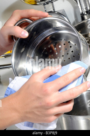 MANN, TROCKNEN VON TÖPFEN UND PFANNEN Stockfoto