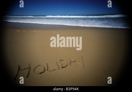 Urlaub in der Sonne am Strand Flut an einem goldenen Sandstrand gelangenden zu schreiben Stockfoto