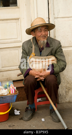 Ein blinder sitzt zufrieden in einer Straße in der Altstadt von Hanoi Vietnam Abschaltdruck Stockfoto