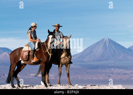 Chile, Atacama-Wüste. Im Chat während einer Pause in einem Pferd Trekking Las Cornicas Grat mit dem perfekten Kegel des Volcan Licancabur im Hintergrund Stockfoto