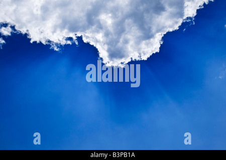 Blauer Himmel mit Sonnenstrahlen hinter den Wolken scheint Stockfoto