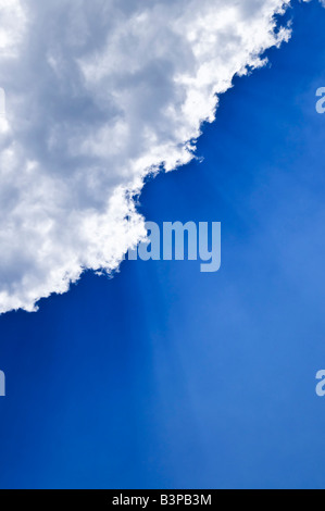 Blauer Himmel mit Sonnenstrahlen hinter den Wolken scheint Stockfoto
