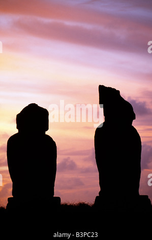 Chile, Osterinsel, Tahai. Sonnenuntergang über dem Pazifik erfüllten zwei der Moais auf der Plattform des Ahu Vai Uri Stockfoto