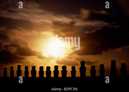 Chile, Osterinsel, Tongariki. Mondaufgang über fünfzehn kolossalen Steinstatuen oder Moais Tongariki. Die Moais stehen auf ihrer Plattform oder Ahu an der Ostküste der Insel am Fuße der Halbinsel Poike. Ahu Tongariki ist die größte Plattform auf der Insel auf über 200m in der Länge und hat die meisten Maois. Einige sind 10 Meter hoch. Die überwiegende Mehrheit der Osterinsel 800 + Moais wurden aus Tuffstein beobachtet auf der Seite des Rano Raraku zwischen 700-1500AD gemeißelt. Stockfoto