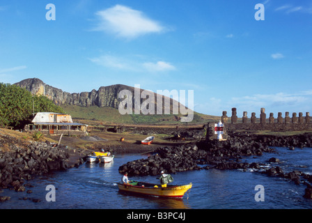 Chile, Osterinsel, Tongariki. Fischer darauf vorbereiten, begeben Sie sich vom kleinen Hafen am Tongariki mit den Umriss des Rano Roraku Vulkan und die fünfzehn kolossalen Steinstatuen oder Moais Tongariki im Hintergrund. Die Moais stehen auf ihrer Plattform oder Ahu an der Ostküste der Insel am Fuße der Halbinsel Poike. Ahu Tongariki ist die größte Plattform auf der Insel auf über 200m in der Länge und hat die meisten Maois. Einige sind 10 Meter hoch. Die überwiegende Mehrheit der Osterinsel 800 + Moais wurden aus Tuffstein beobachtet auf der Seite des Rano Raraku zwischen 700-1500AD gemeißelt. Stockfoto