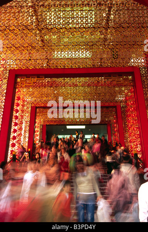 China, Hongkong, Kowloon. Besucher strömen durch den Eingang zum Einkaufszentrum Sterne Haus dekoriert für Chinese New Year. Das Einkaufszentrum befindet sich auf Victoria Harbour direkt am Ocean Terminal in Kowloon, Hongkong. Stockfoto