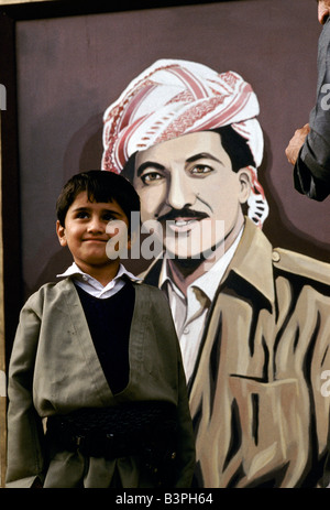 KURDISTAN ", NORTHER IRAK: EIN JUNGE STEHT VOR EINER GEMALTEN PLAKAT DER KURDISCHEN FÜHRER MASOUD BARZANI, OKTOBER 1991 Stockfoto