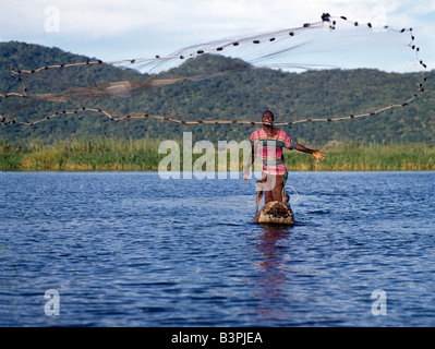 Südliche Malawi Malawi, Shire River. Ein Fischer in einem Einbaum wirft sein Netz in der Shire River, Lake Malawi nur Auslass Stockfoto