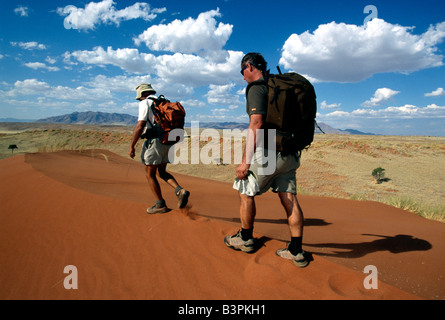 Männer, die zu Fuß über die Dünen, Tok Tokkie Trail, NamibRand Nature Reserve, Namibia, Afrika Stockfoto