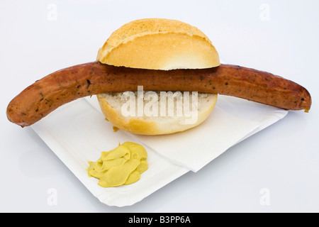 Ein Krakauer Wurst in ein Brot Brötchen mit Senf auf einem Pappteller Stockfoto