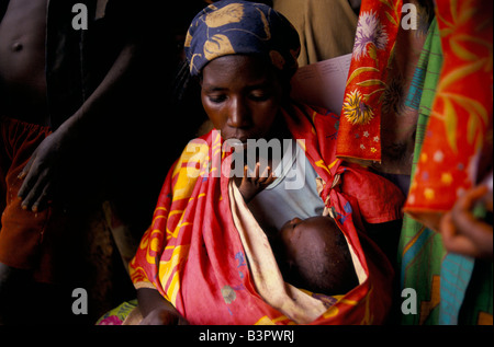 BURUNDISCHE FLÜCHTLINGE IN RUANDA. MOKINDO LAGER HÄLT MEHR ALS 50.000. EINE FRAU UND IHR JUNGES BABY WARTEN AUF MEDIZINISCHE BEHANDLUNG Stockfoto