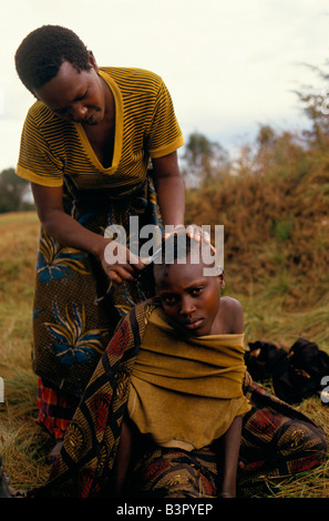 Junge Frau, die immer eines Haarschnitts in einem Lager für Vertriebene Tutsis in Lager unter Schutz der Armee in der Nähe von Mwaro, Mugamba Provinz Stockfoto