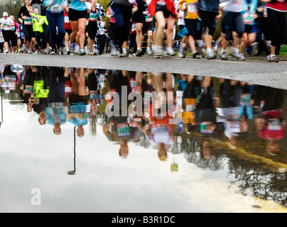 Marathonläufer spiegelt sich in der Pfütze Stockfoto