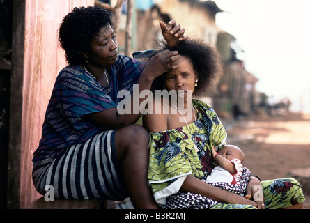 SIERRA LEONE ", FRAU FLECHTEN JUNGE MUTTER HAARE, FREETOWN, JULI 1992 Stockfoto