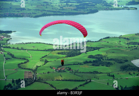 Gleitschirm fliegen über ländliche See Landschaft in der Nähe von Tegelberg in den Bayerischen Alpen in Deutschland Stockfoto