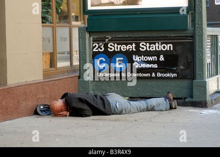 Ein Obdachloser schläft in der Nähe einer u-Bahn-Eingang im New Yorker Stadtteil Chelsea Stockfoto