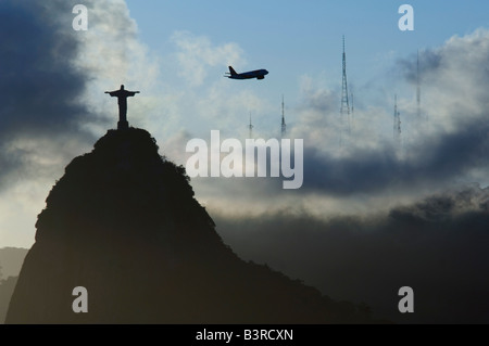 Die Statue von Christus dem Erlöser Silhouette bei Sonnenuntergang/Dämmerung an der Spitze des Berges Corcovado in Rio De Janeiro. Stockfoto