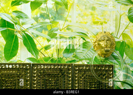 Grove House, Oxford, UK, Nov 2006: gold Löwenkopf Handtuch-Halter und grün Pflanze print Tapete über Kupfer Bad Fliesen Stockfoto