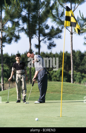 Vater und Teenager Sohn zusammen Golf spielen Vater Golf Fertigkeiten Stockfoto