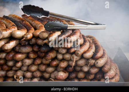 Barneville, Normandie, Frankreich. Frisch gegrillte Würstchen auf einem Stall auf dem Wochenmarkt Stockfoto