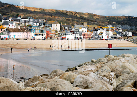 Sandstrand am Meer bei Lyme Regis in Dorset mit strahlendem Sonnenschein und einem dunklen bewölkten Himmel Stockfoto