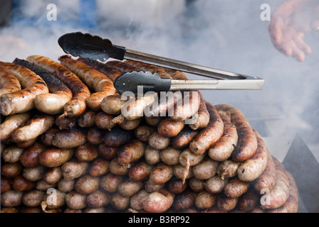 Barneville, Normandie, Frankreich. Frisch gegrillte Würstchen auf einem Stall auf dem Wochenmarkt Stockfoto