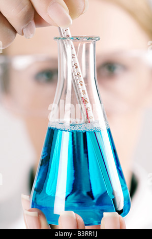 Wissenschaftler mit einem konischen Kolben und Thermometer in einem Labor hautnah Stockfoto