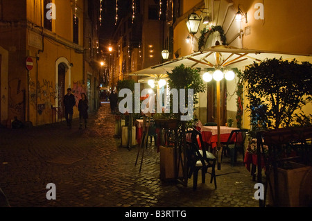 Fußgänger gehen entlang der Straße mit Restaurants im Stadtteil Trastevere Rom Italien gesäumt Stockfoto