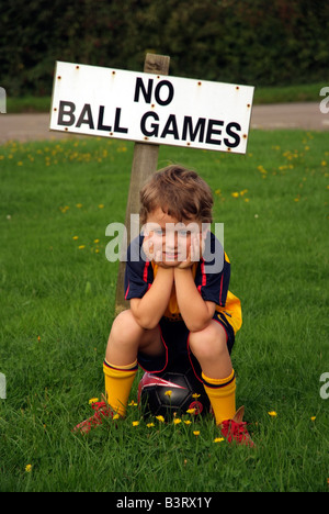 Kleiner Junge und Fußball tragen Fußball-Trikot mit einem keine Ballspiele steht registrieren nirgendwo, um spielen Stockfoto