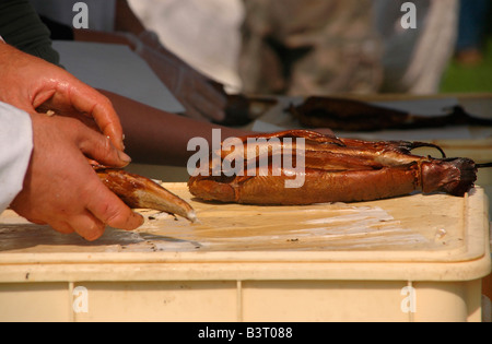 Ein Mann hüllt Arbroath Smokies für einen Kunden. Stockfoto