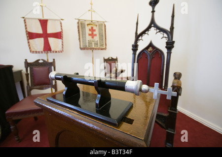 Knights Templar Streitkolben auf einem Tisch in der Großmeister Position in einem Masonic Hall, mit Flaggen im Hintergrund Stockfoto