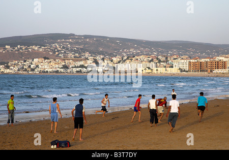 Eine Gruppe von Jugendlichen Fußball spielen am Strand im Abendlicht. Tanger, Marokko. Stockfoto