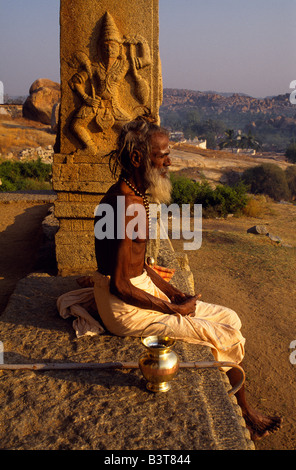 Indien, Karnataka, Hampi. Ein wandernder Asket oder Sadhu, ruht auf der Veranda eines Schreines auf Hemakuta Hill Stockfoto